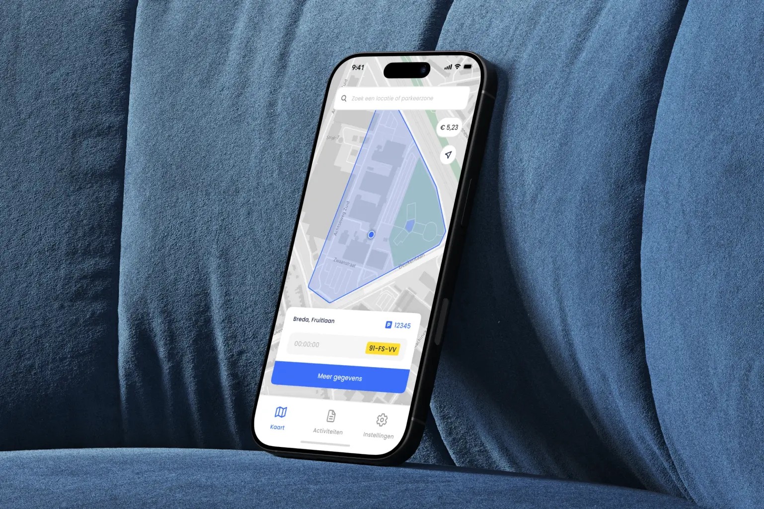 iPhone op een blauwe bank met de kaart van de SimplePark-app: de parkeerzone, de zonecode en het kenteken
